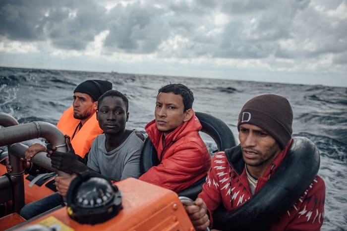 10 | MEDITERRANEAN SEA &ndash; KEVIN MCELVANEY December 2016 &ndash; Young men hold on tight as a speedboat transfers them from their wooden boat to the MSF/SOS search and rescue vessel, Aquarius, in the rough seas of the Mediterranean, off the northern coast of Libya.