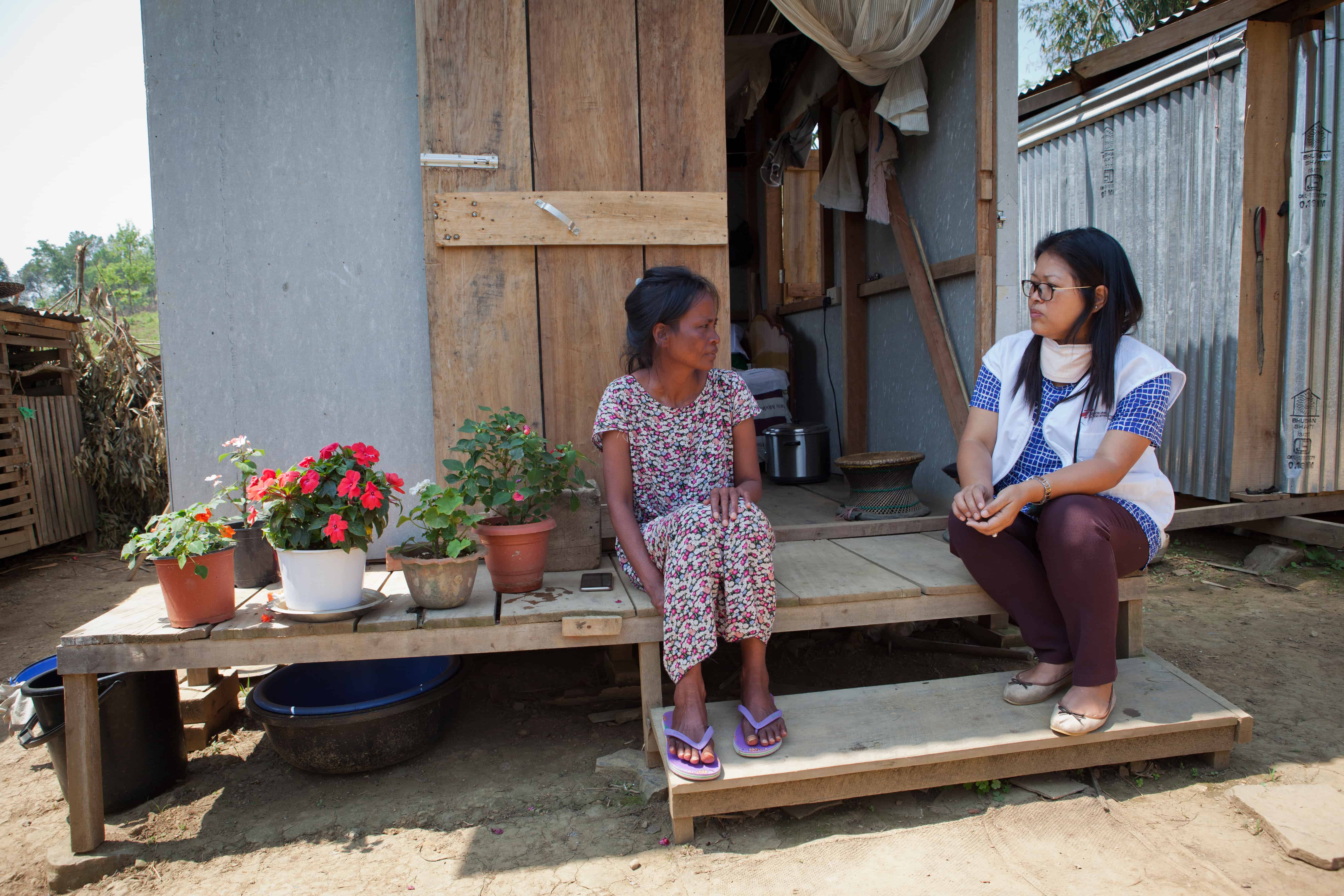 Neilam Synrem, who is receiving treatment for MDR-TB, talks to an MSF counsellor in front of the house MSF built for her next to her family home, in order to reduce the chances of transmission of the disease to the rest of her family. Manipur, India, April 2019. © JAN-JOSEPH STOK