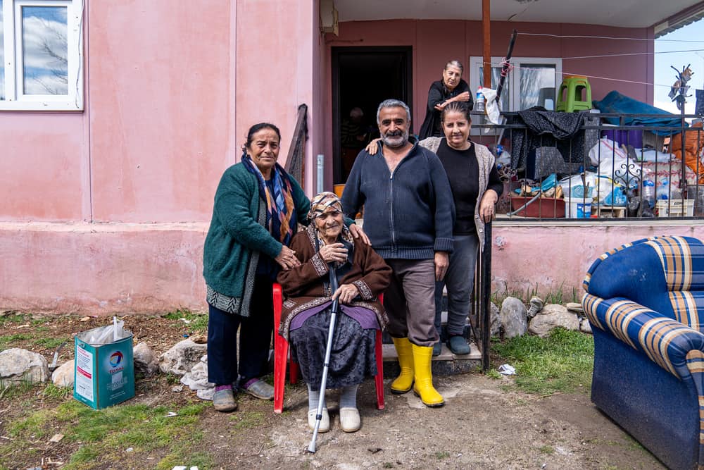 Semra Karaca, Sultan Kodaş, Hüseyin Kodaş and Şengül Kodaş (from left to right) live together as a family in Ören village, on the outskirsts of Malatya, Türkiye. They have been greatly affected by the recent earthquakes, as well as heavy flooding in the region. "There are earthquakes on the one hand and rain on the other. We don’t know what will happen in the future. I’m here with my wife, my siblings, my children, and my mother. Our belongings are drowned in water because of the flood, we can't find anything to wear, the neighbour brought us these clothes for now. We were staying in a tent, but the tent got flooded too. We are now trying to dry what we took out of the house, including our family photos. The children are scared. The situation is very dire”, says Hüseyin Kodaş