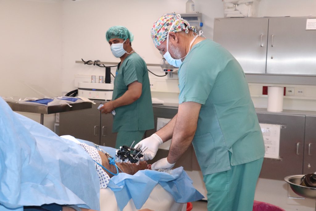 An MSF doctor performs wound care on a patient’s foot in the operating theatre of the MSF Trauma Centre in Kunduz. ©️ Tasal Khogyani/MSF